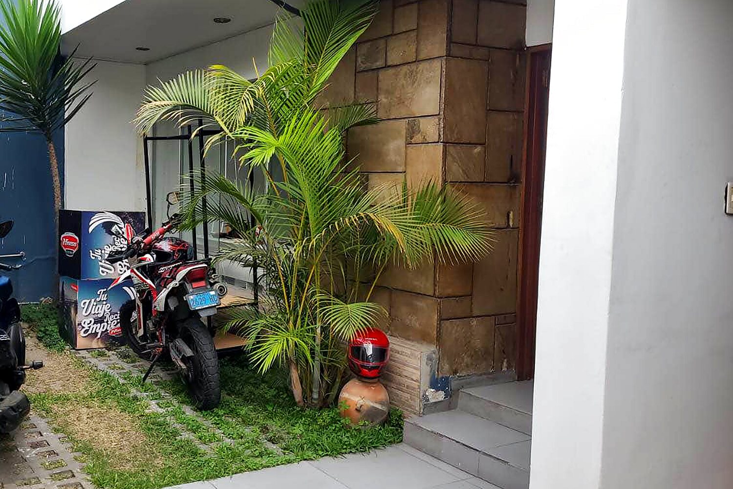 Patio de ingreso con jardín y espacio para motos