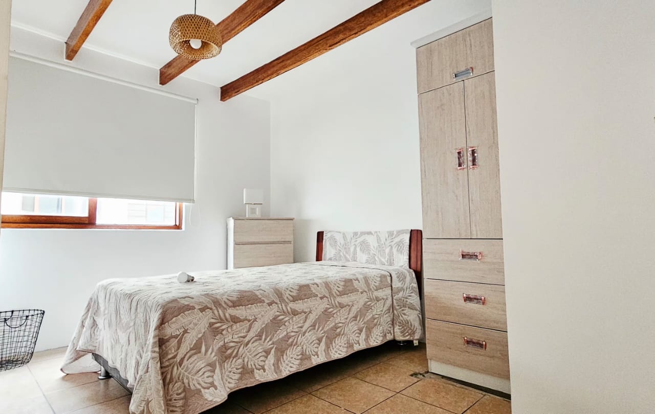 Habitación amoblada con cama, ropero, cómoda y ventana con luz natural