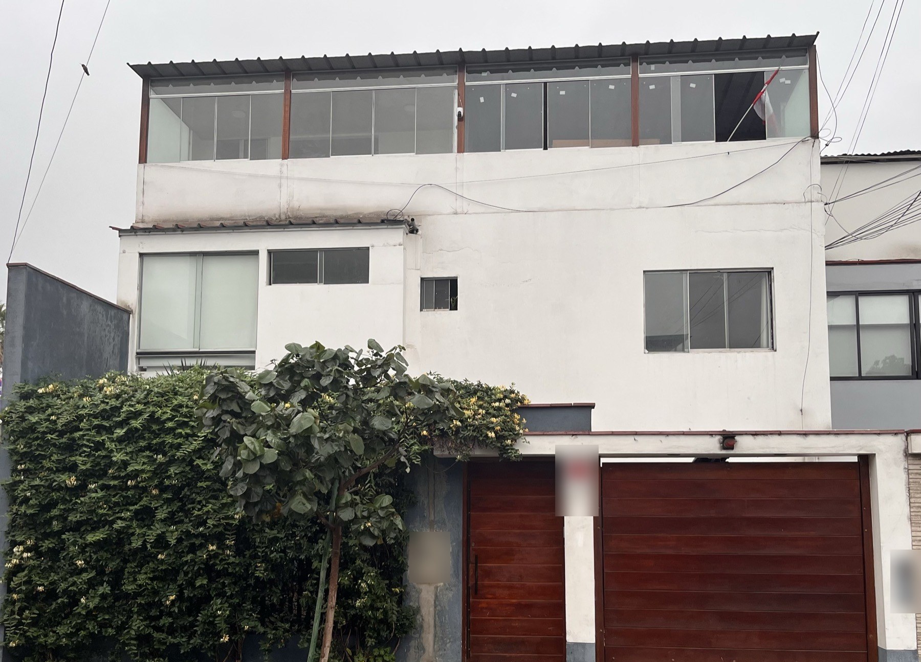 Fachada de la casa: el cuarto ocupa el nivel superior vidriado